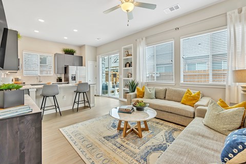 a living room and kitchen with a couch and a table